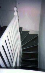 Winding narrow staircase with white ballustrade