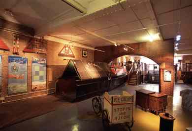 ground floor view, ice cream tricycle in foreground, narrowboat and arch to the rear.