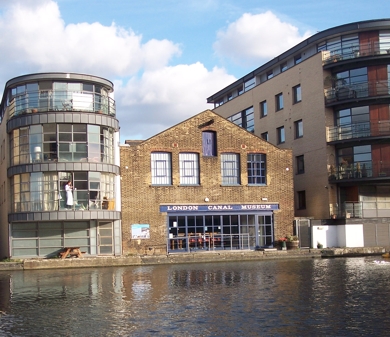 view of rear of museum, in sunshie, with reflections in water